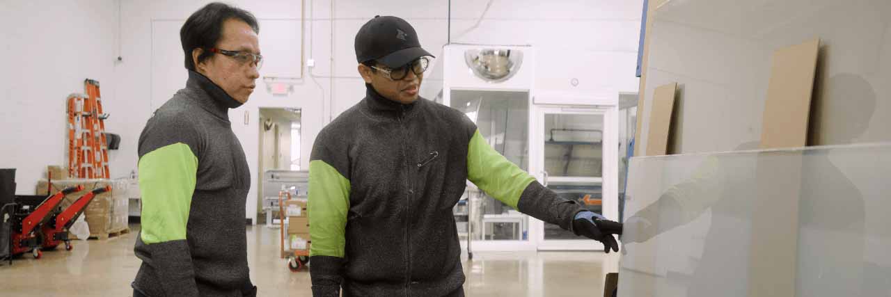 Cardinal employees examining glass together